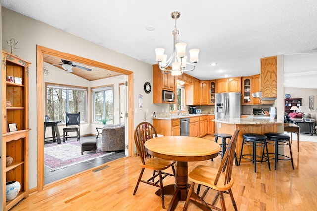 dining room featuring ceiling fan with notable chandelier, visible vents, light wood-style floors, vaulted ceiling, and recessed lighting