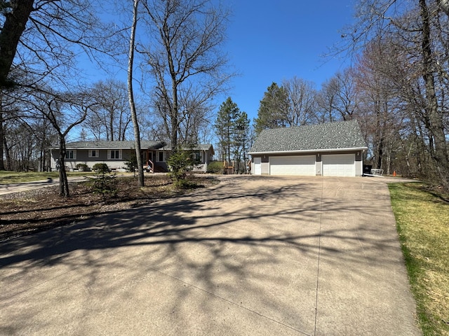 view of front of house with concrete driveway, an outdoor structure, and a garage