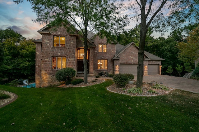 traditional home with an attached garage, brick siding, concrete driveway, and a front yard