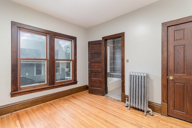 2807 17th Ave S, Minneapolis, MN 55407 - empty room featuring radiator heating unit, baseboards, and light wood-style flooring