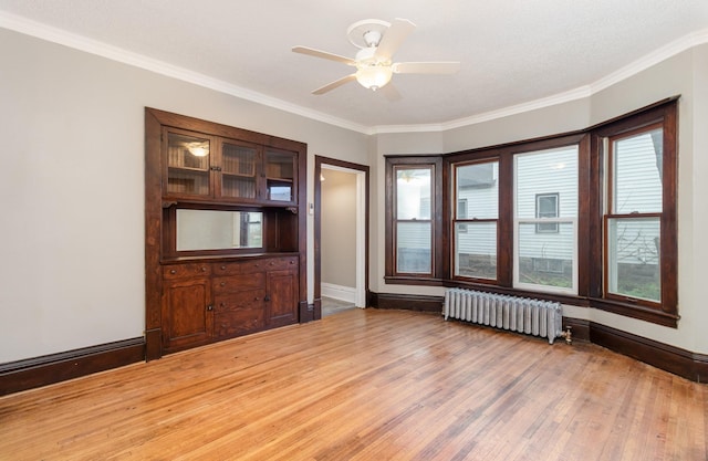 2807 17th Ave S, Minneapolis, MN 55407 - unfurnished room featuring radiator, crown molding, light wood-style floors, ceiling fan, and baseboards