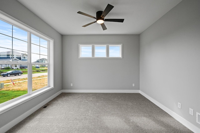 spare room with baseboards, a ceiling fan, and carpet flooring