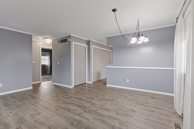 1513 Creek Meadows Dr NW, Coon Rapids, MN 55433 - spare room featuring crown molding, wood finished floors, a textured ceiling, and a chandelier
