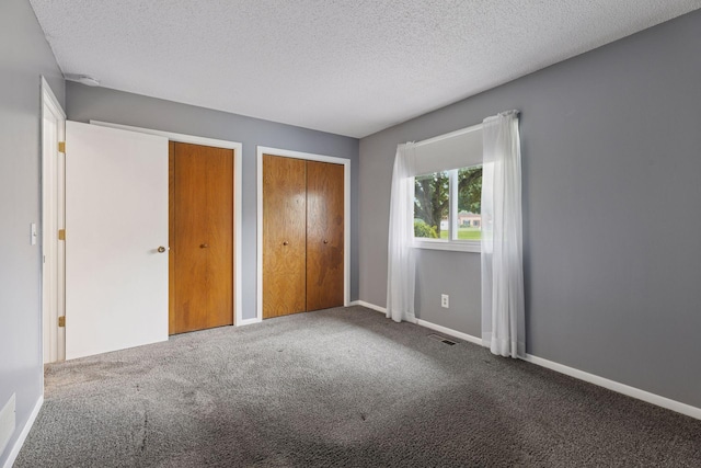 1513 Creek Meadows Dr NW, Coon Rapids, MN 55433 - unfurnished bedroom featuring multiple closets, carpet, and a textured ceiling