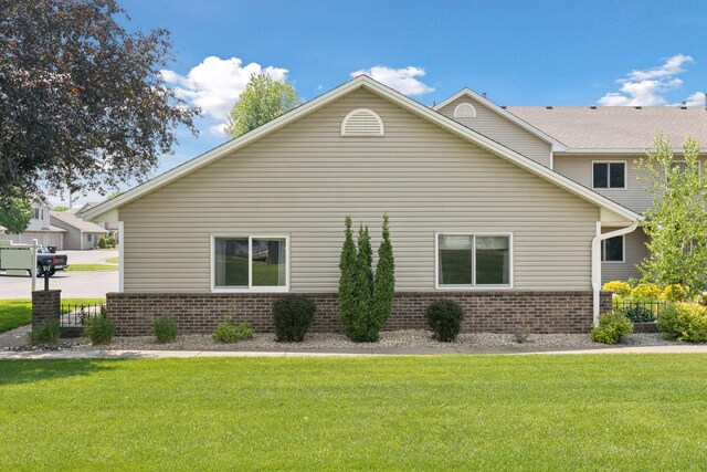 1513 Creek Meadows Dr NW, Coon Rapids, MN 55433 - view of side of home with brick siding and a lawn