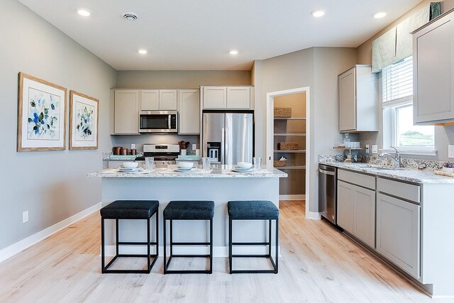526 Goldenrod Trl, Waconia, MN 55387 - kitchen with light wood-style flooring, a center island, appliances with stainless steel finishes, and a kitchen breakfast bar
