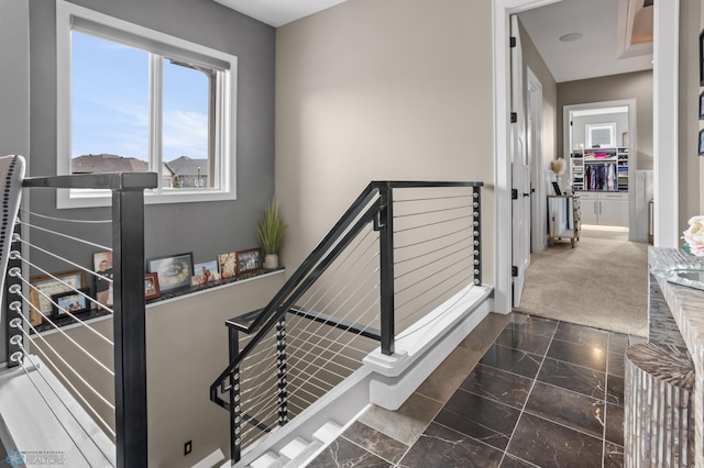 stairway with marble look tile flooring and baseboards