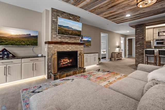 living area featuring carpet, wooden ceiling, a fireplace, baseboards, and recessed lighting