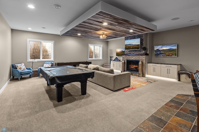playroom with recessed lighting, a fireplace, carpet flooring, baseboards, and stone tile floors