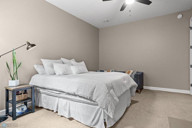 bedroom featuring light colored carpet, baseboards, and a ceiling fan