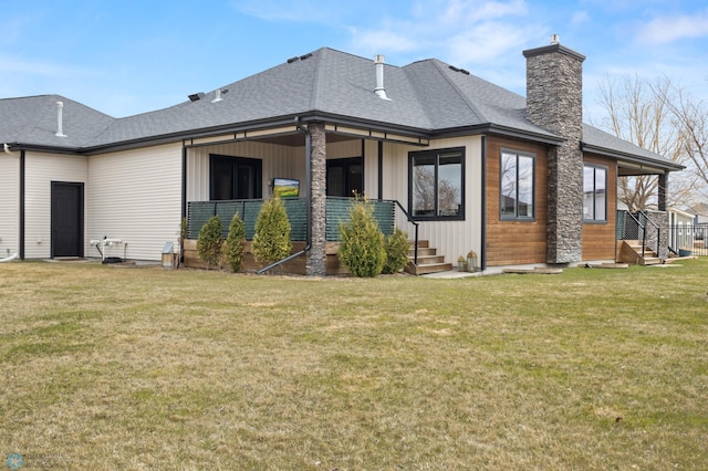 back of house with a shingled roof, a chimney, a yard, and board and batten siding