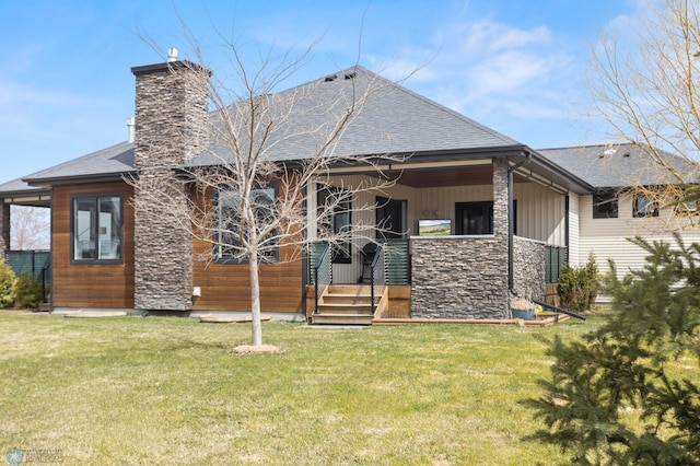 rear view of property with a yard, a chimney, and a shingled roof