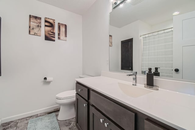 bathroom with baseboards, curtained shower, vanity, and toilet