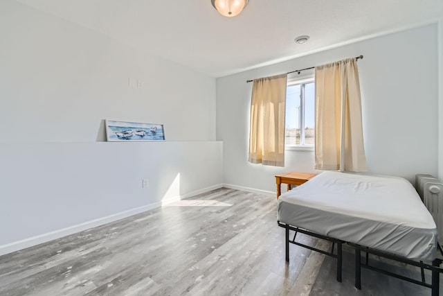 bedroom featuring baseboards and wood finished floors