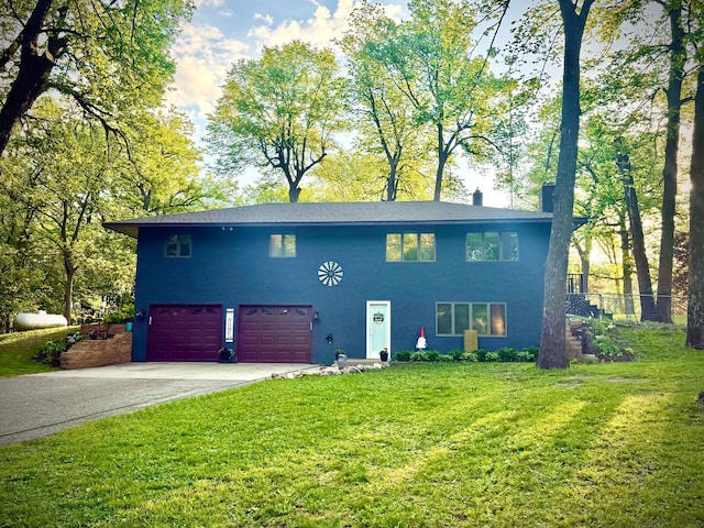 view of front of property featuring asphalt driveway, a garage, and a front lawn