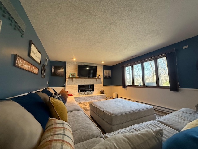 living room with a textured ceiling, a baseboard heating unit, and a fireplace