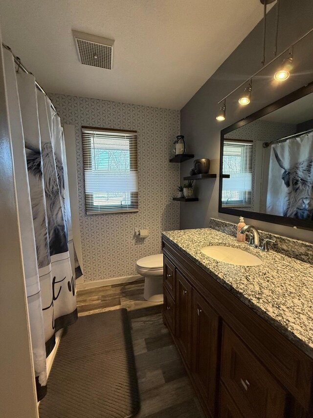 full bathroom featuring wood finished floors, wallpapered walls, toilet, vanity, and a shower with curtain