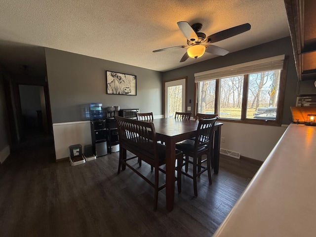 dining area with a textured ceiling, ceiling fan, dark wood-style floors, and baseboards