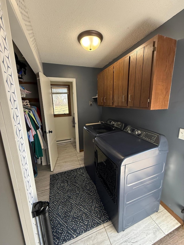 clothes washing area with cabinet space, a baseboard radiator, separate washer and dryer, a textured ceiling, and baseboards