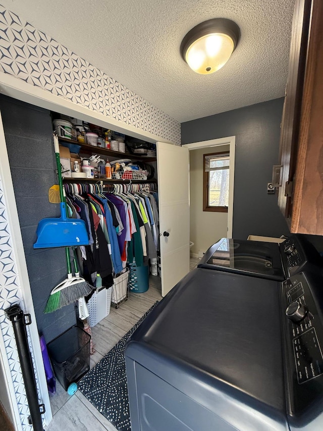 clothes washing area featuring washer and dryer and a textured ceiling