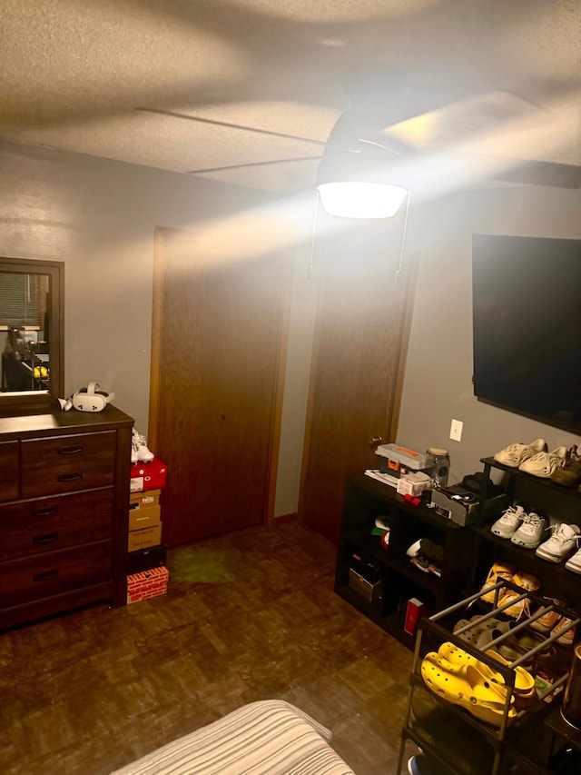 bedroom with ceiling fan and a textured ceiling