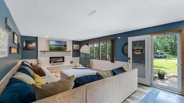19593 Minnesota Highway 22, Greenleaf Twp, MN 55355 - living area with a textured ceiling, a fireplace, and light wood-style flooring