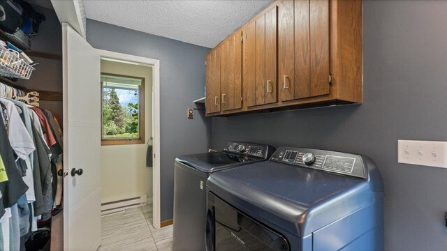 19593 Minnesota Highway 22, Greenleaf Twp, MN 55355 - laundry area featuring a baseboard heating unit, cabinet space, separate washer and dryer, a textured ceiling, and baseboards