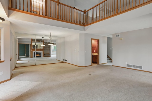 13409 44th Cir NE, Saint Michael, MN 55376 - unfurnished living room with a warm lit fireplace, a high ceiling, baseboards, stairway, and carpet