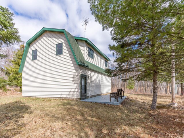 10823 Bollenbacher Rd, Garrison Twp, MN 56401 - view of home's exterior with a gambrel roof and a patio area
