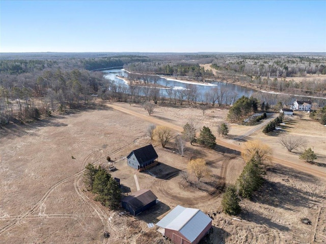 aerial view of property's location with a large body of water and a forest