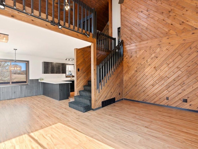 stairway featuring wood finished floors and wood walls