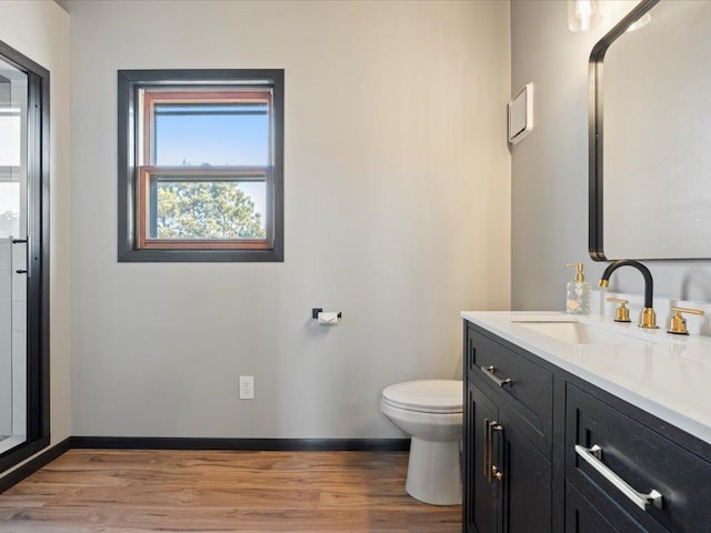 full bath with wood finished floors, vanity, toilet, and baseboards