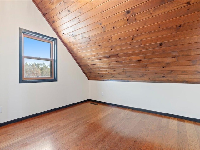additional living space with wooden ceiling, baseboards, vaulted ceiling, and wood finished floors