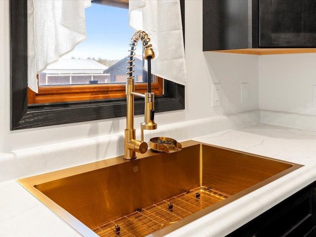 kitchen view of a sink and light stone counters