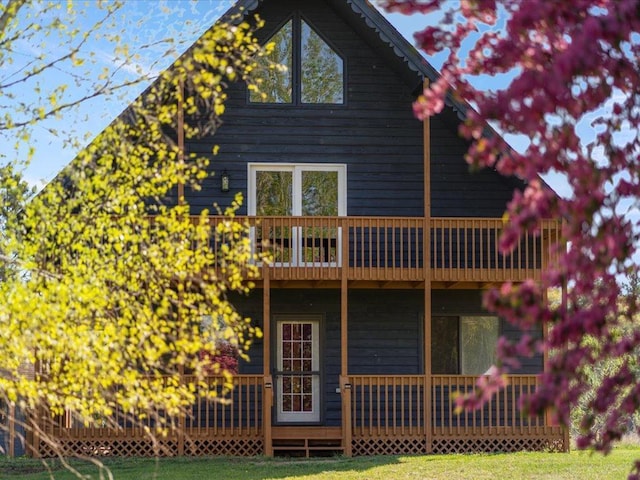 rear view of house featuring a yard and a balcony