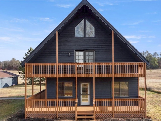 back of property featuring a wooden deck and a yard