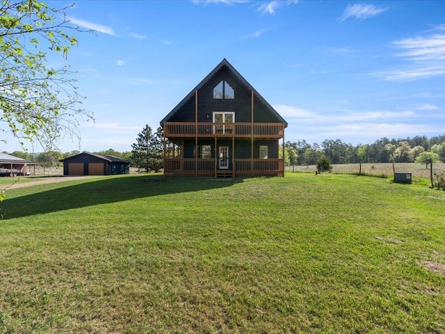 rear view of property featuring a detached garage, a yard, an outdoor structure, and a balcony