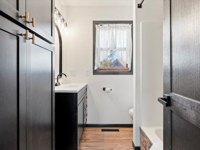 14122 13th Ave SW, Sylvan Twp, MN 56473 - full bath featuring vanity, a bathtub, toilet, wood finished floors, and baseboards