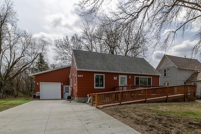 view of front of property with a garage, a shingled roof, a deck, and concrete driveway