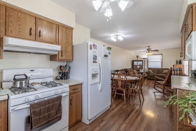 kitchen featuring brown cabinetry, ceiling fan, under cabinet range hood, and white appliances