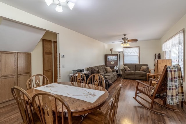 dining space featuring a ceiling fan, wood finished floors, and vaulted ceiling