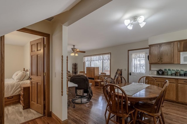 dining space featuring light wood-style flooring, visible vents, and a ceiling fan
