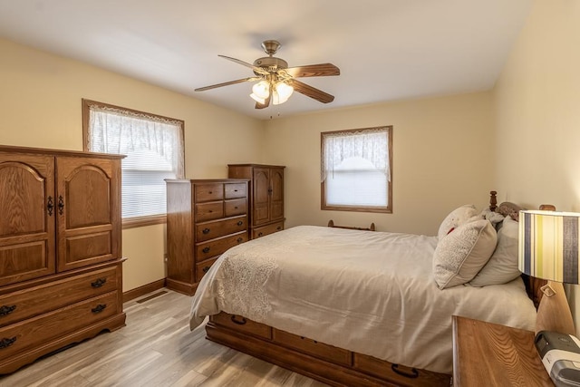 bedroom featuring light wood-style flooring, baseboards, and ceiling fan