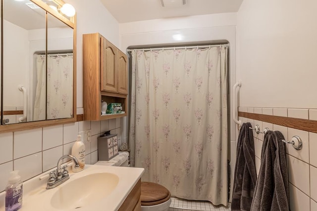 bathroom with toilet, a shower with curtain, vanity, and tile walls