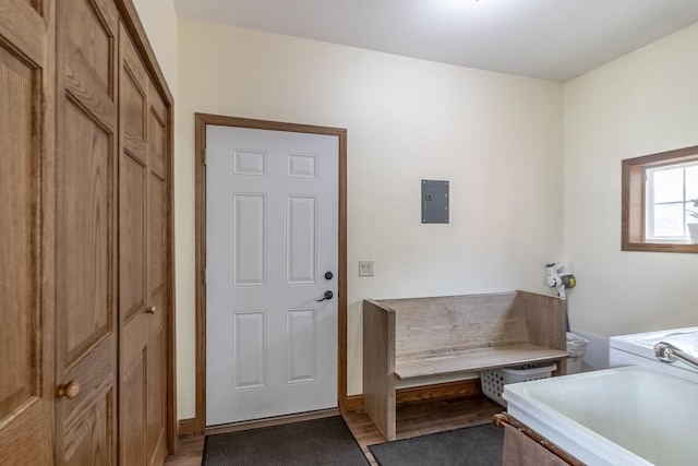 laundry room with electric panel, a sink, laundry area, and light wood-style floors
