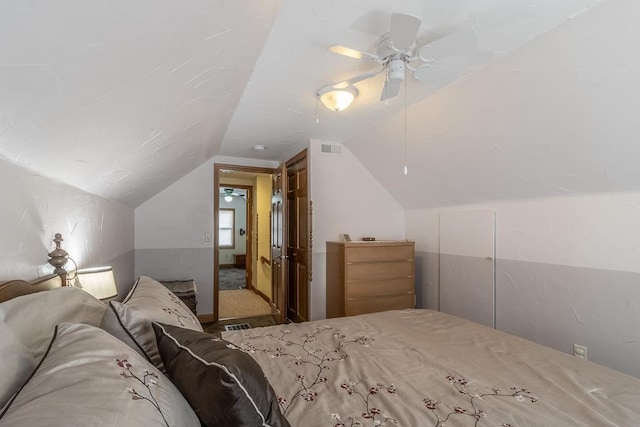 bedroom featuring lofted ceiling, visible vents, and ceiling fan