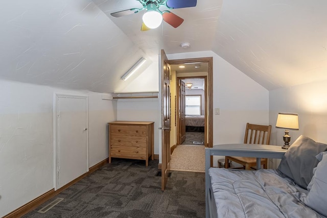 carpeted bedroom with lofted ceiling, a ceiling fan, and visible vents