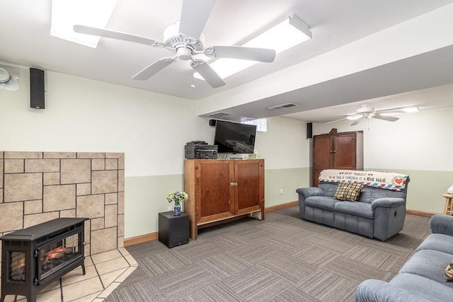living room with baseboards, a ceiling fan, and visible vents