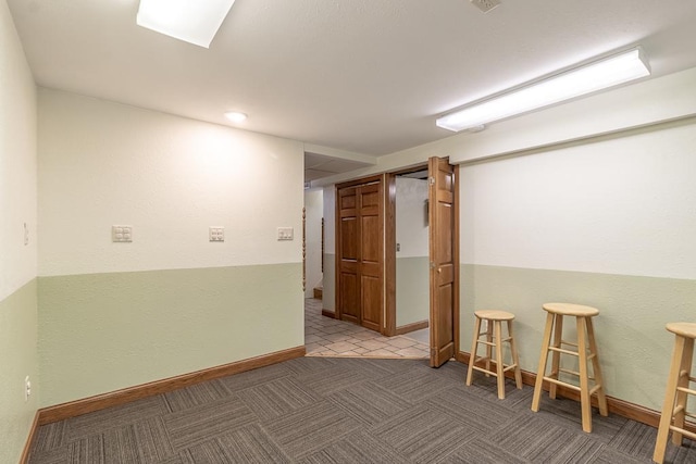 empty room featuring baseboards and carpet