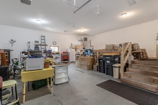 garage featuring white refrigerator and a garage door opener